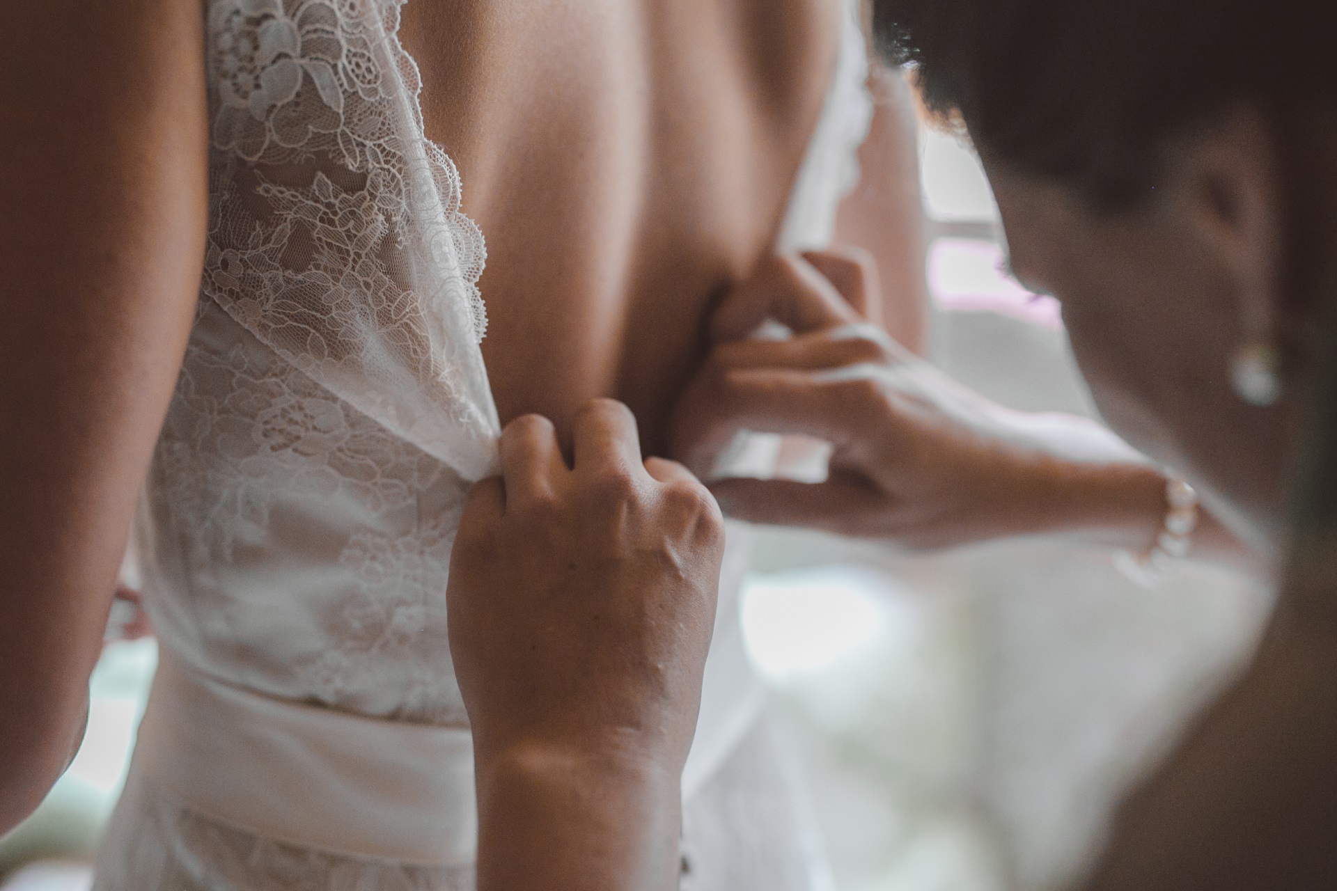 Brautkleid mit tiefem Rückenausschnitt mit Stickerei anziehen mit Hilfe - Feelings Braut & Festmoden